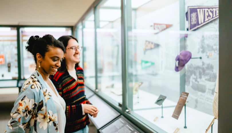 Two people look at a display of historic objects in Museum London.